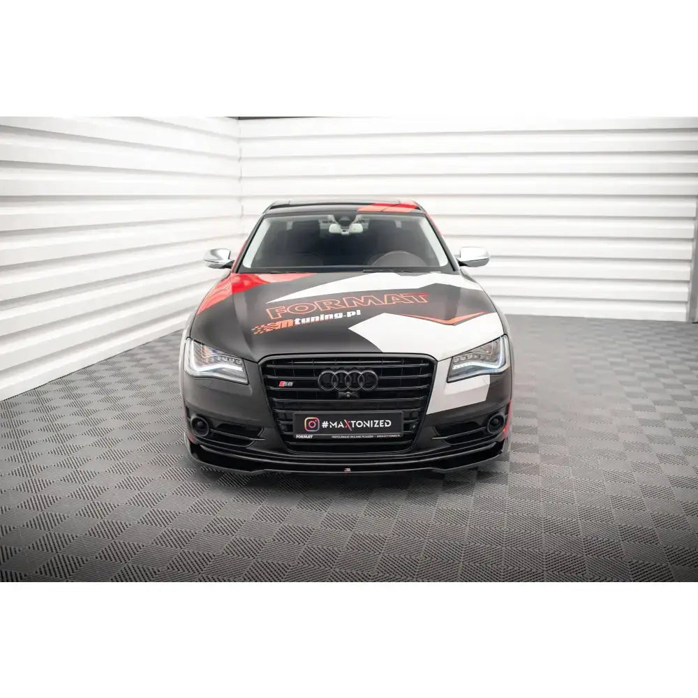 Frontsplitter på Audi S8 D4 med fargerik folie og store logoer, sett rett forfra i lyst rom.