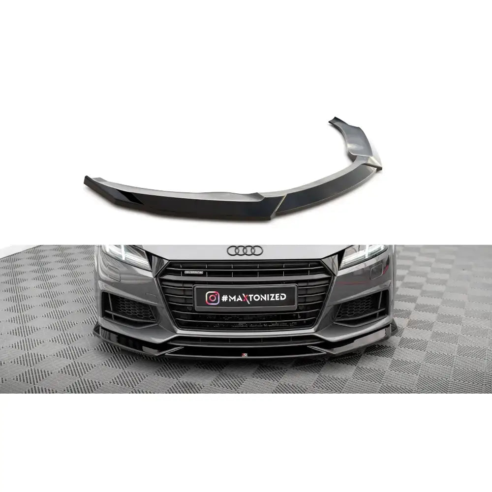 Frontleppe V1 Audi TT S i blank sort plast montert på grå bil, avbildet forfra på mønstret gulv.
