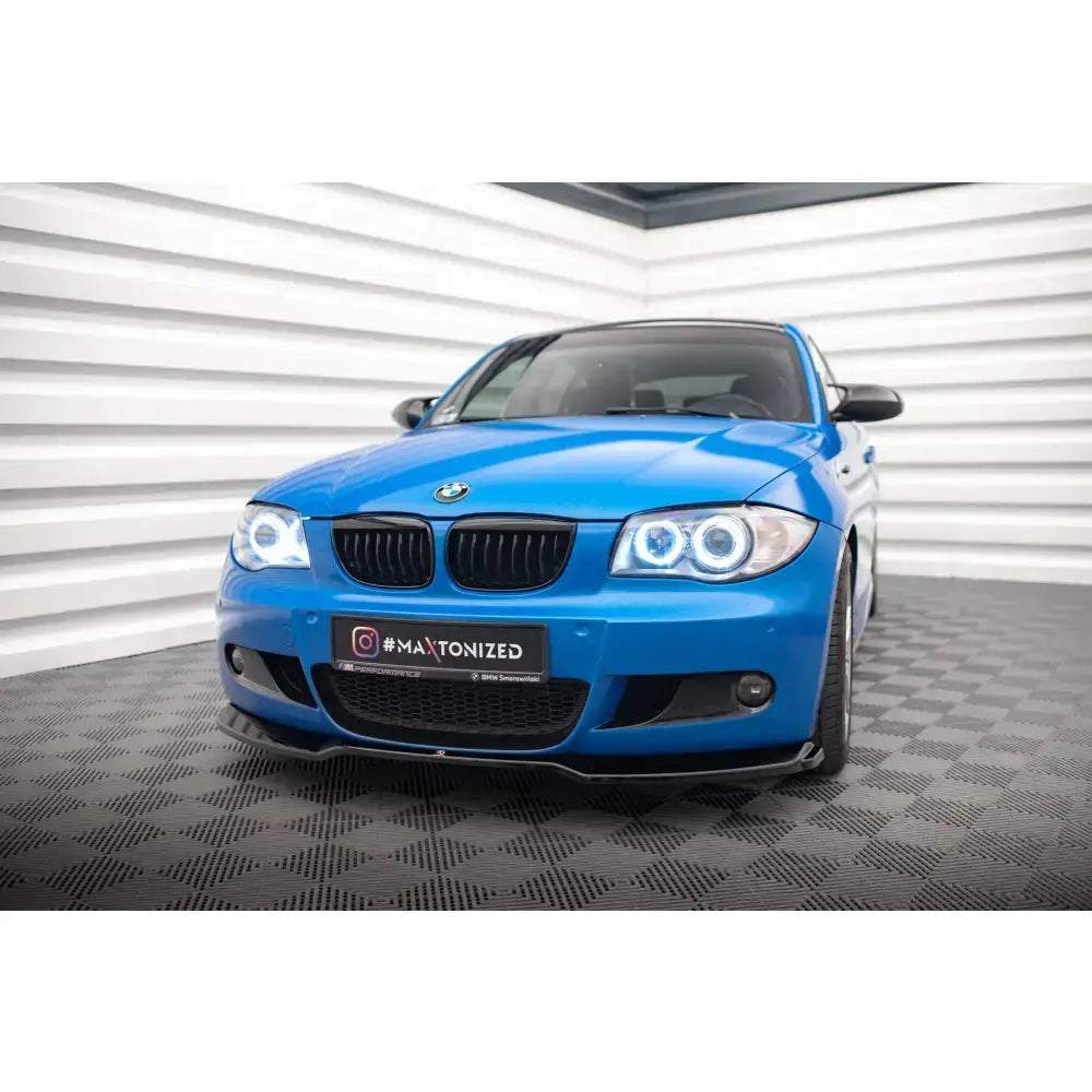 Frontsplitter på BMW 1 M-Pack E87 Facelift, blå bil forfra med svarte grilldetaljer og LED-lys.