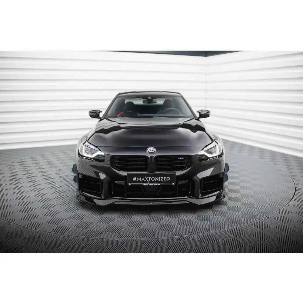 Frontsplitter på BMW M2 G87, sort sportsbil forfra med markerte luftinntak i lyst studio.