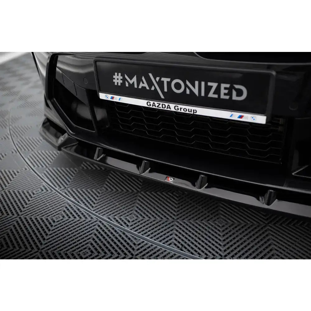 Front lip til BMW X3 M F97 Facelift, sort spoiler i blank plast med aerodynamiske detaljer, nærbilde forfra.