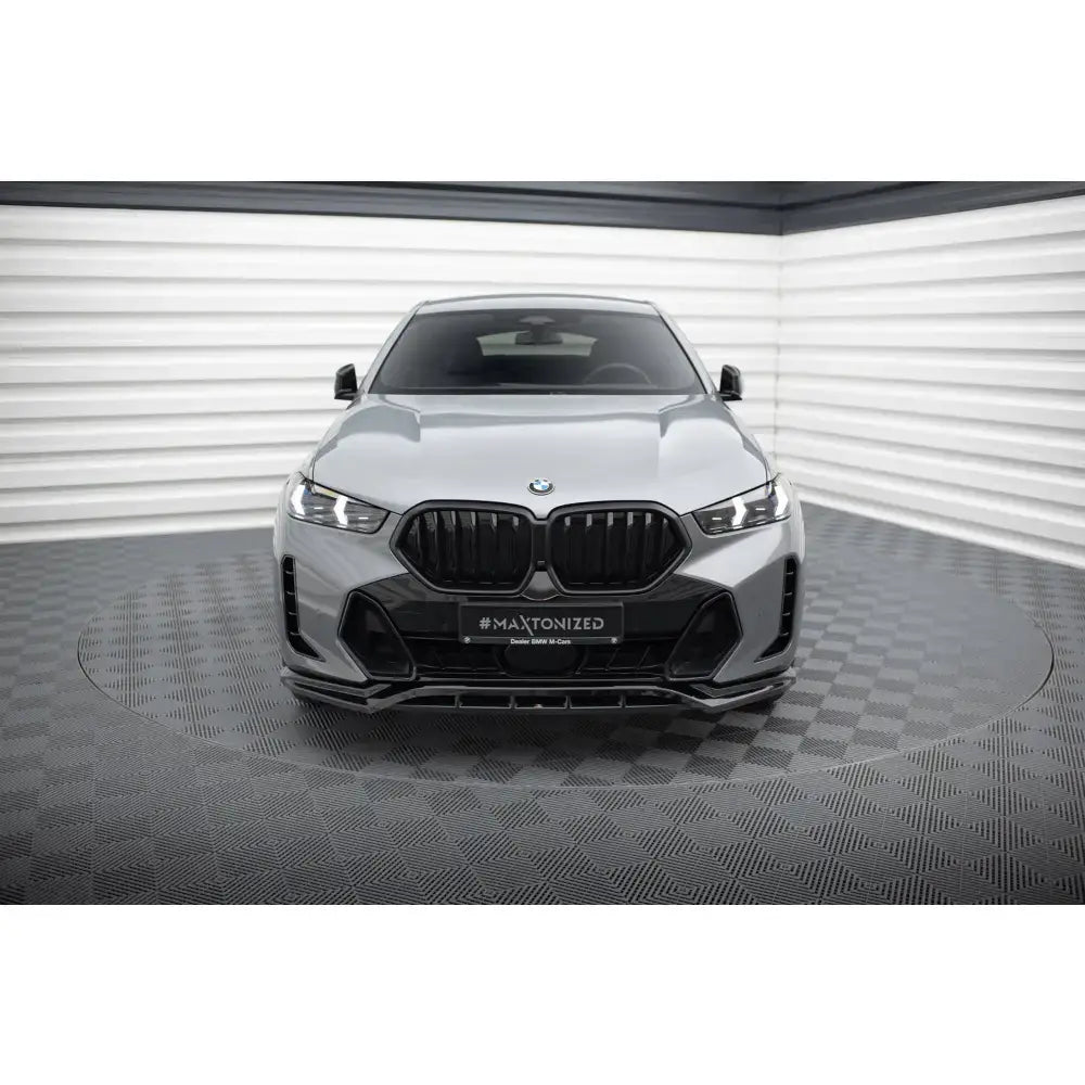 Frontsplitter på BMW X6 M-Pack G06 Facelift med sorte grilldetaljer sett forfra i lyst rom.