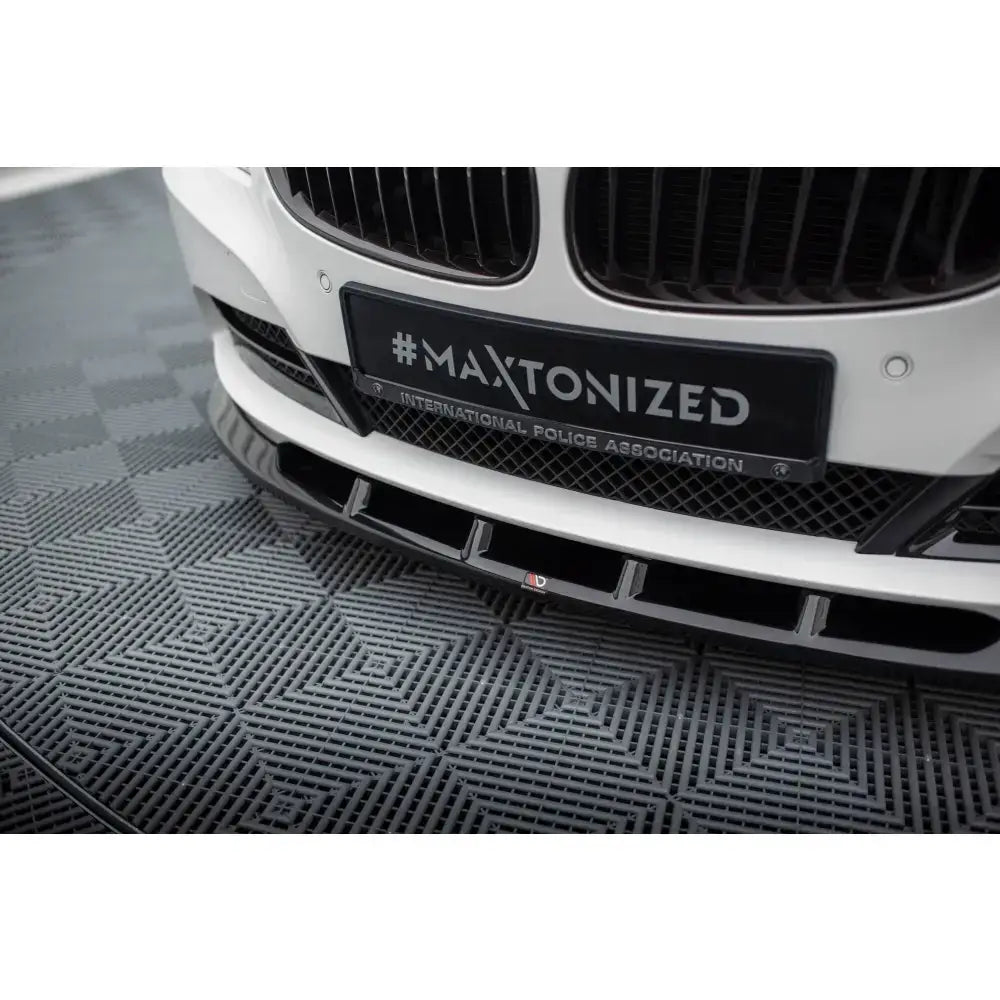 Front lip for BMW Z4 E89 sort frontsplitter i plast montert under hvit støtfanger, sett fra lav vinkel.