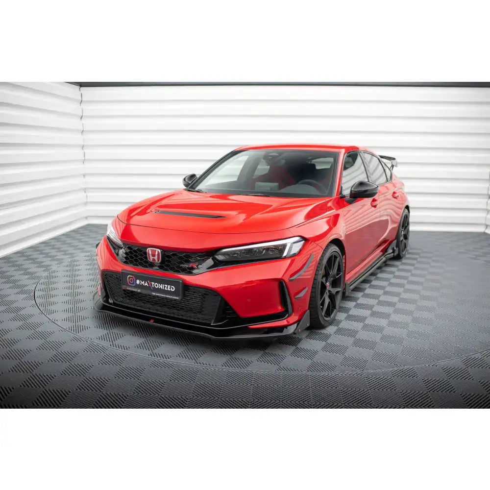 Frontspoiler på rød Honda Civic Type-R Mk 11 med sorte felger og hette-ventilasjon, innendørs.