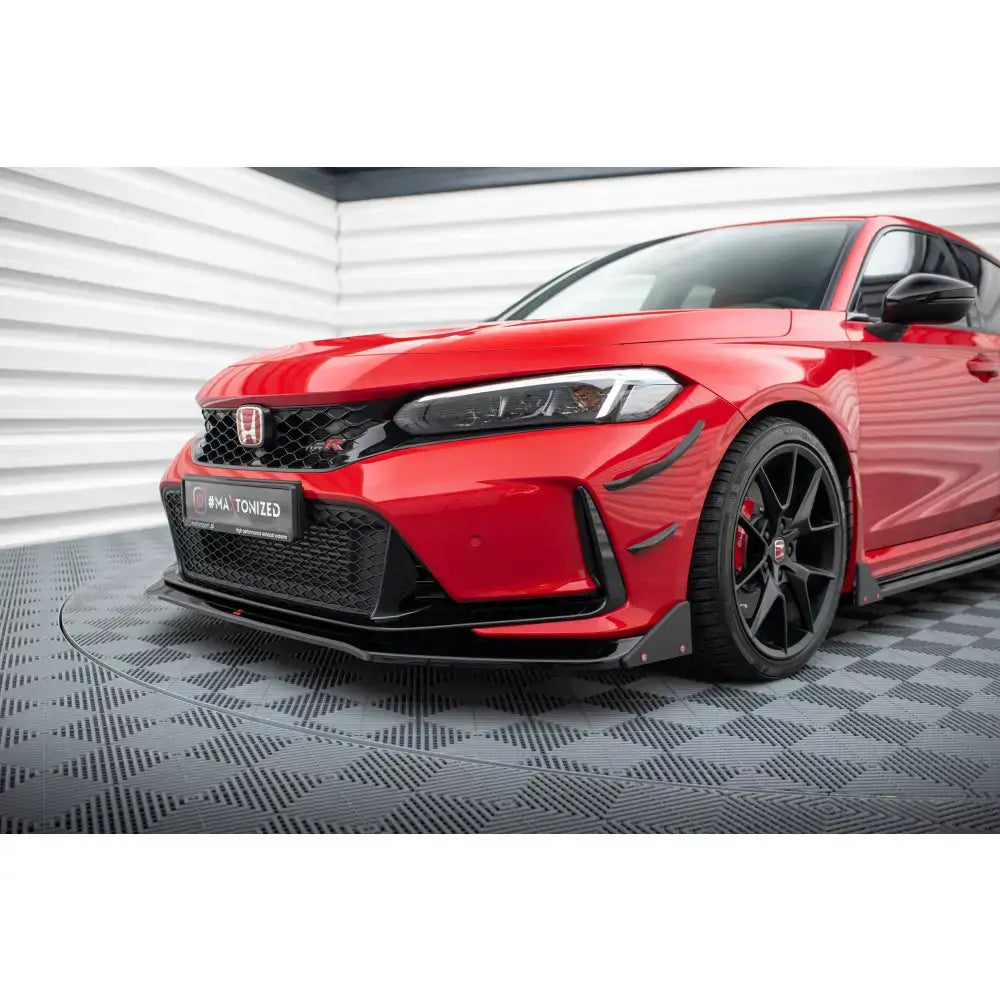 Front lip på rød Honda Civic Type-R Mk 11 med svart spoiler og flaps, sett fra skrått forhjørne.