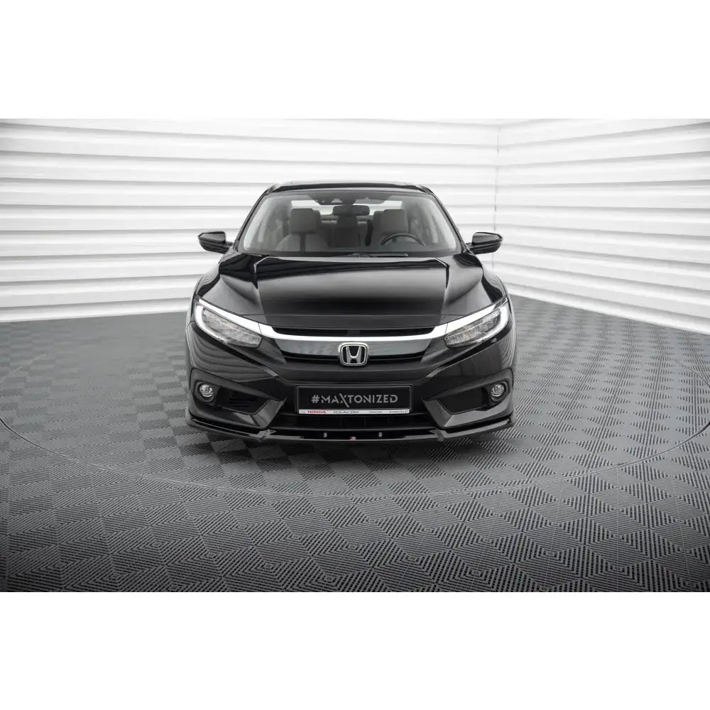 Frontsplitter på Honda Civic Mk10, sort bil sett forfra med kromgrill og lyst interiør i opplyst rom.