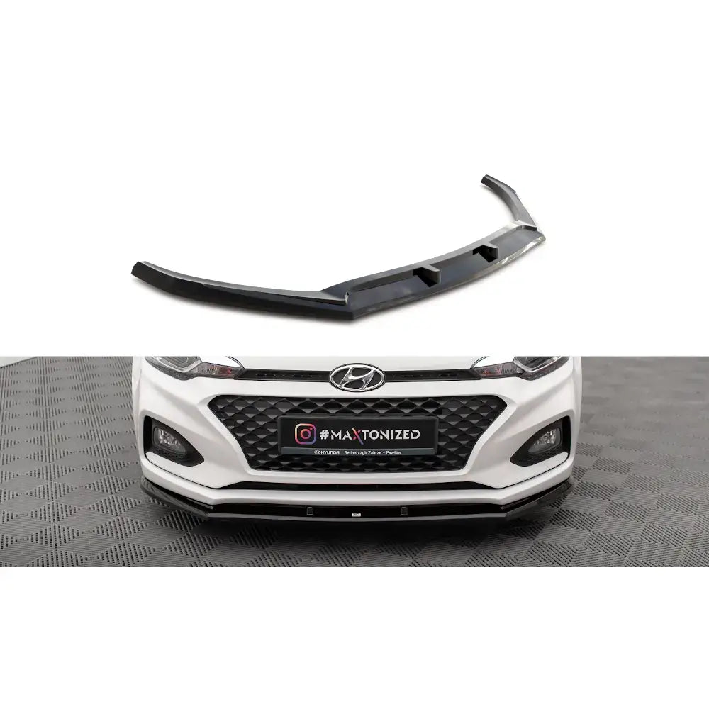 Frontleppe V1 Hyundai I20 Mk2 Facelift i sort plast montert på hvit bil, sett forfra.