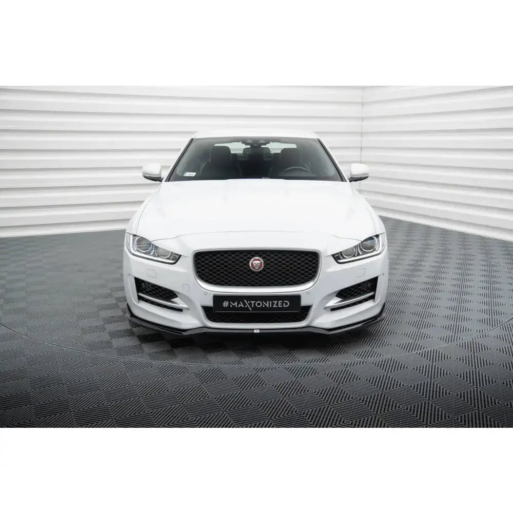Frontsplitter på Jaguar XE R-Sport X760, hvit bil forfra med sort grill og kromdetaljer mot lyst bakteppe.