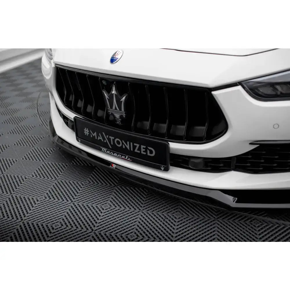 Front lip på Maserati Ghibli Mk3 Facelift, hvit bil med sort grill og #MAXTONIZED-skilt, nærbilde.