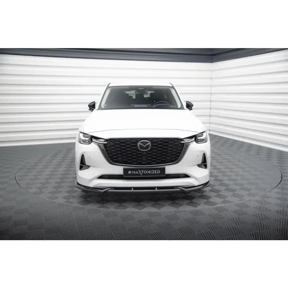 Frontsplitter på Mazda CX-60 Mk1 hvit bil med sort grill, sett forfra i lyst fotostudio.
