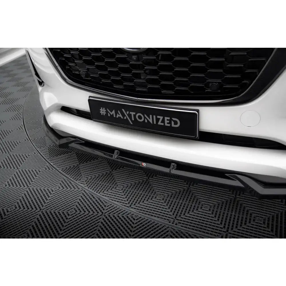 Front lip til Mazda CX-60 Mk1 vist i nærbilde på hvit bil med sort grill og sort leppe under støtfanger.