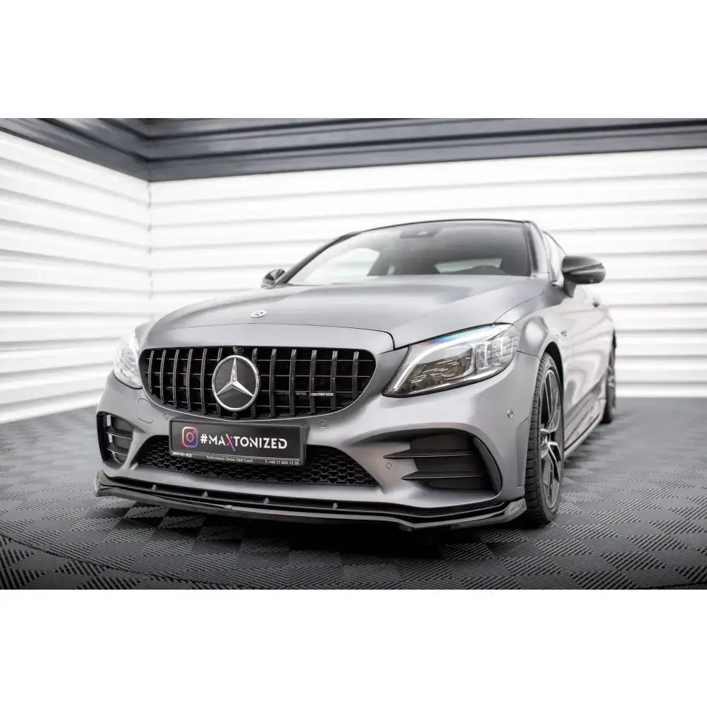 Frontspoiler på Mercedes-AMG C43 Coupe med sort grill, sølvfarget karosseri og mønstret gulv.