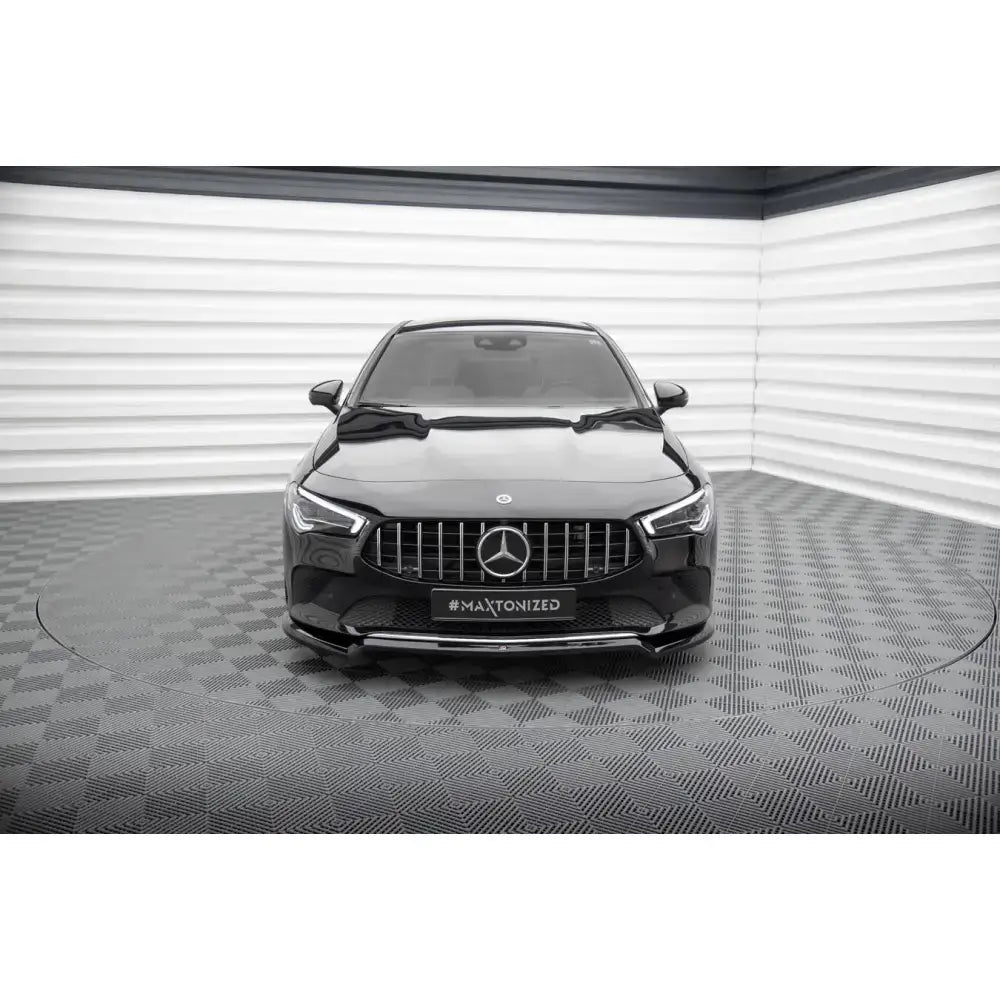 Frontsplitter på Mercedes-Benz CLA C118 sett forfra med sort grill og kromdetaljer i lyst rom.