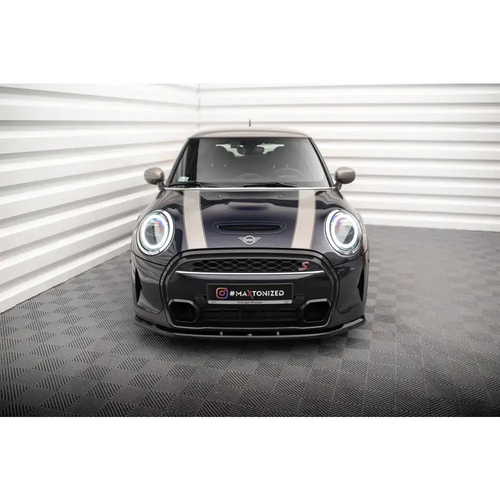 Frontsplitter på sort Mini Cooper S F56 Facelift med beige striper, sett forfra på mørkt gulv.