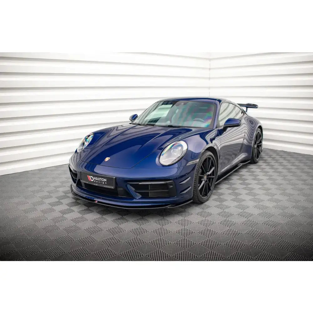 Frontsplitter på Porsche 911 Carrera Aero 992 sett skrått forfra, mørkeblå med svarte felger.