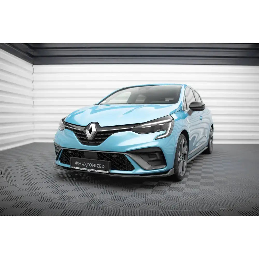 Frontsplitter på Renault Clio RS Line Mk5, lys blå bil med svarte detaljer foran i lyst rom.
