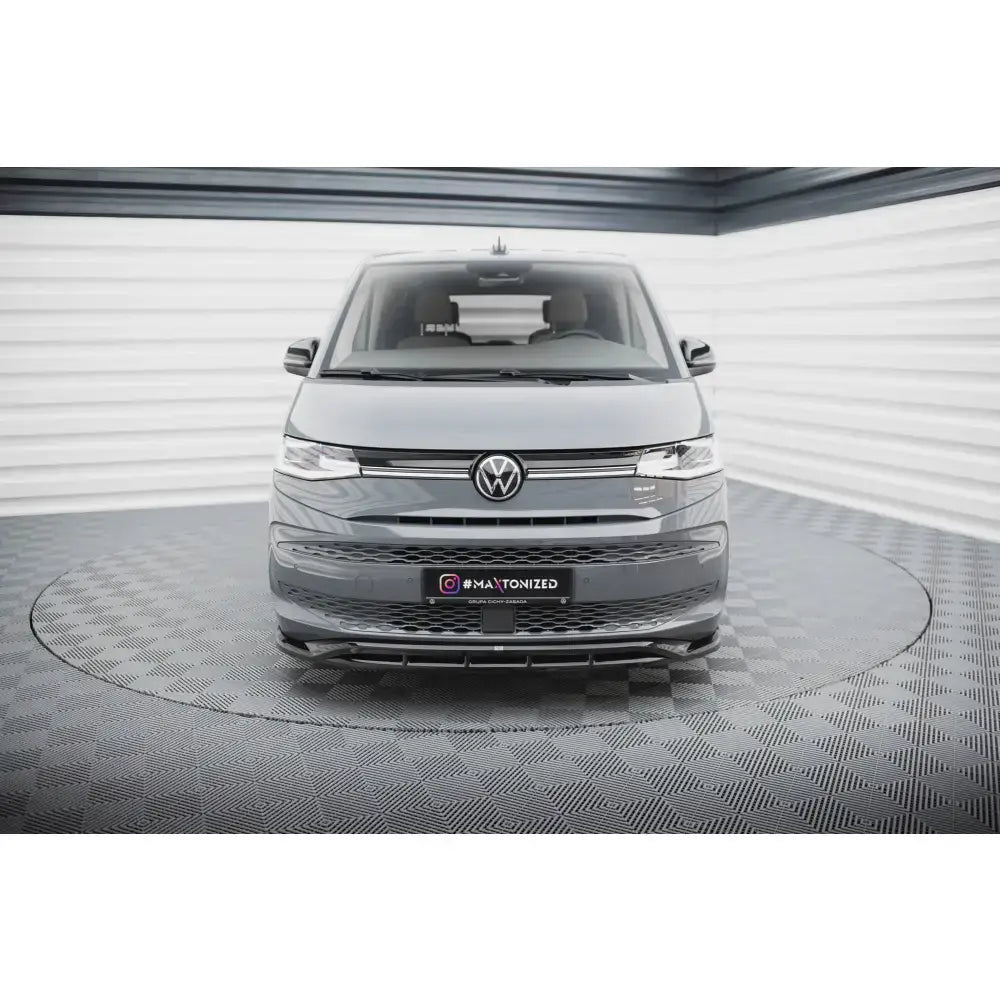 Frontsplitter på Volkswagen Multivan T7, grå varebil sett forfra med sorte detaljer og logo.