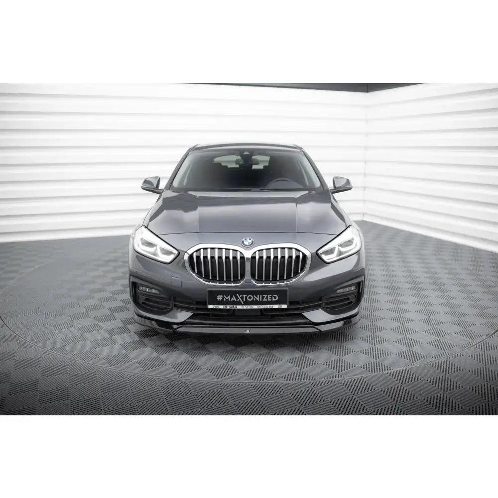 Front lip på BMW 1 F40, grå bil forfra med kromgrill og LED-frontlykter i lyst studio.