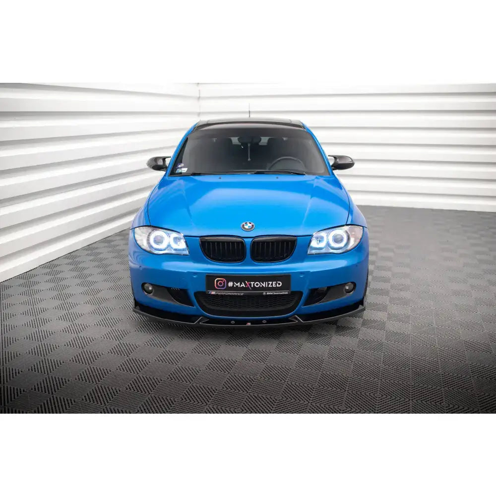Frontspoiler V2 til BMW 1 M-Pack E87 Facelift montert på blå bil med sorte detaljer og LED-frontlykter.