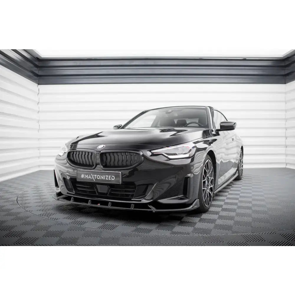 Frontsplitter på sort BMW 2 Coupe G42 med metallic finish og markante luftinntak sett skrått forfra.