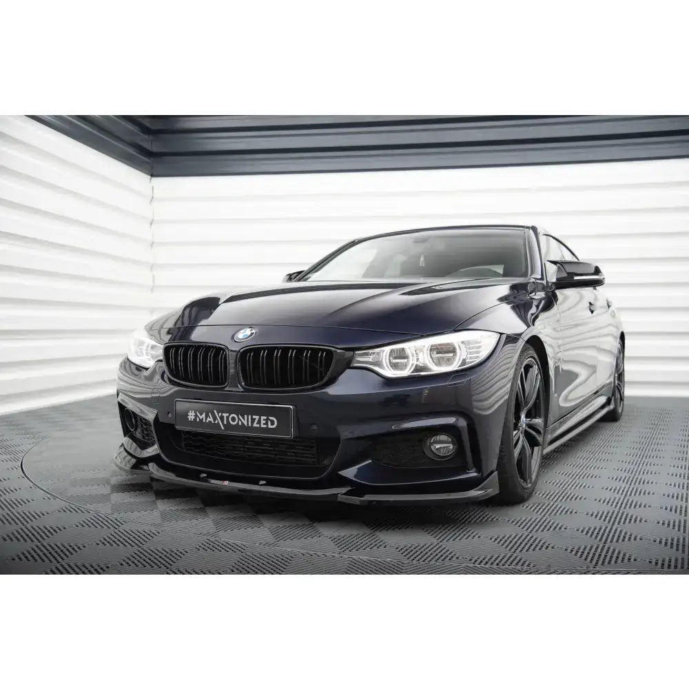 Frontspoiler på svart BMW 4 Gran Coupe M-Pack F36 med sorte felger og LED-lykter i lyst lokale.