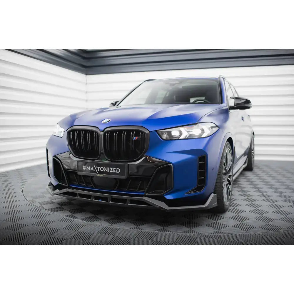 Frontsplitter på blå BMW X5 M-Pack G05 Facelift med sorte detaljer og LED-lys i lyst rom.