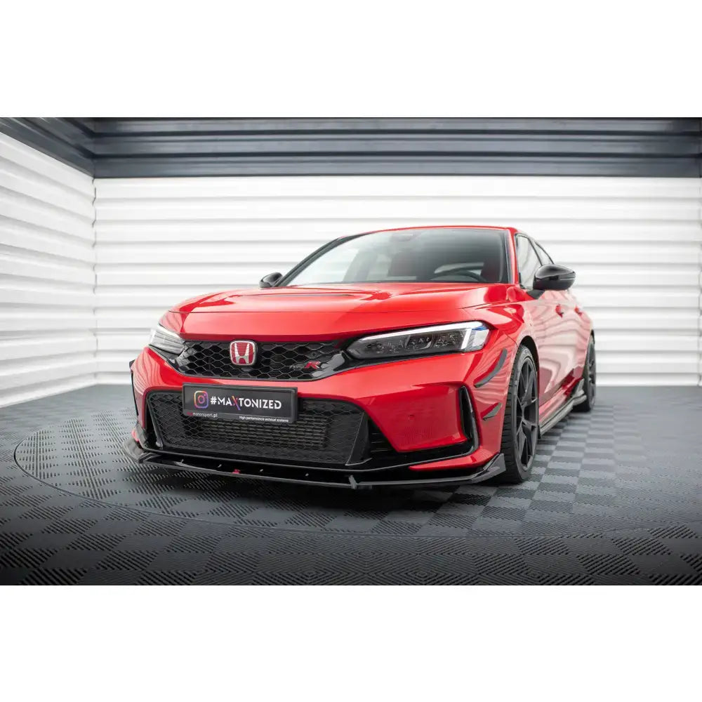 Frontspoiler på rød Honda Civic Type-R Mk 11 vist fra front med sorte detaljer i lyst studio.