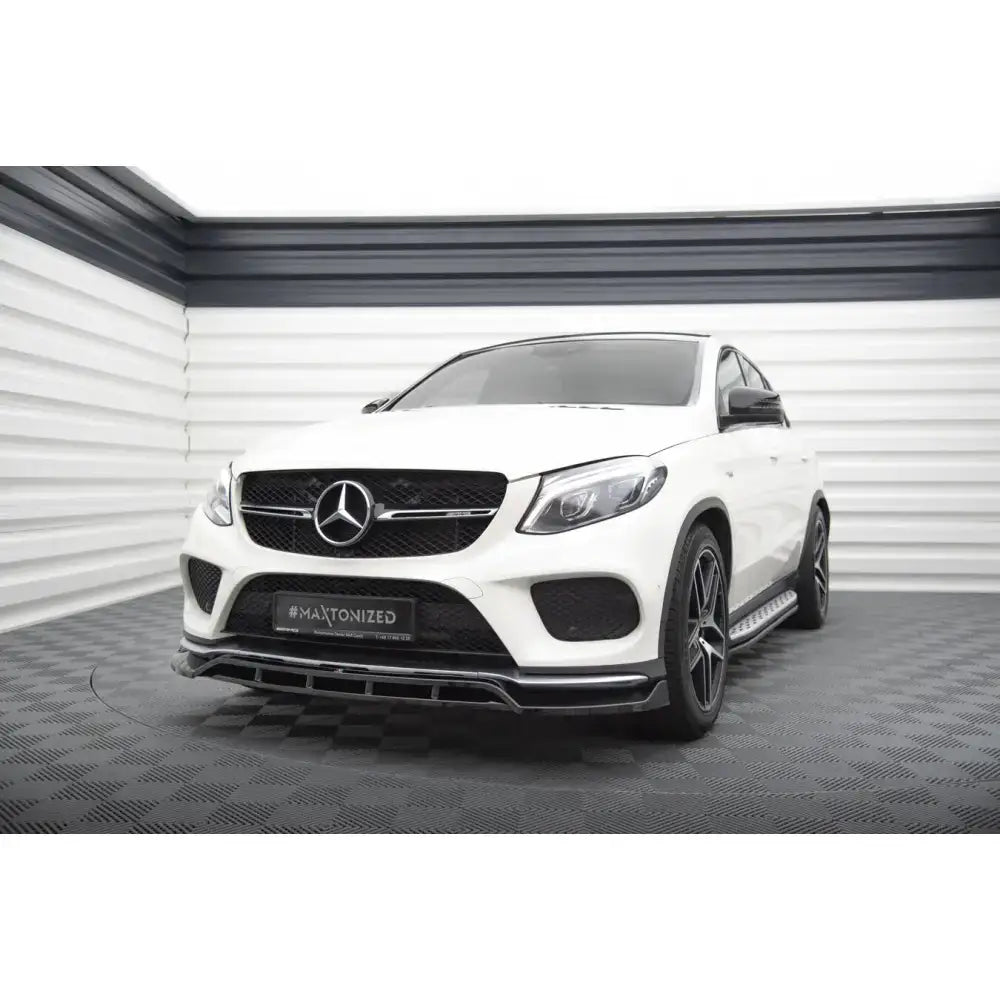 Frontsplitter på hvit Mercedes-Benz GLE Coupe 43 AMG med sorte detaljer og store felger, sett forfra.
