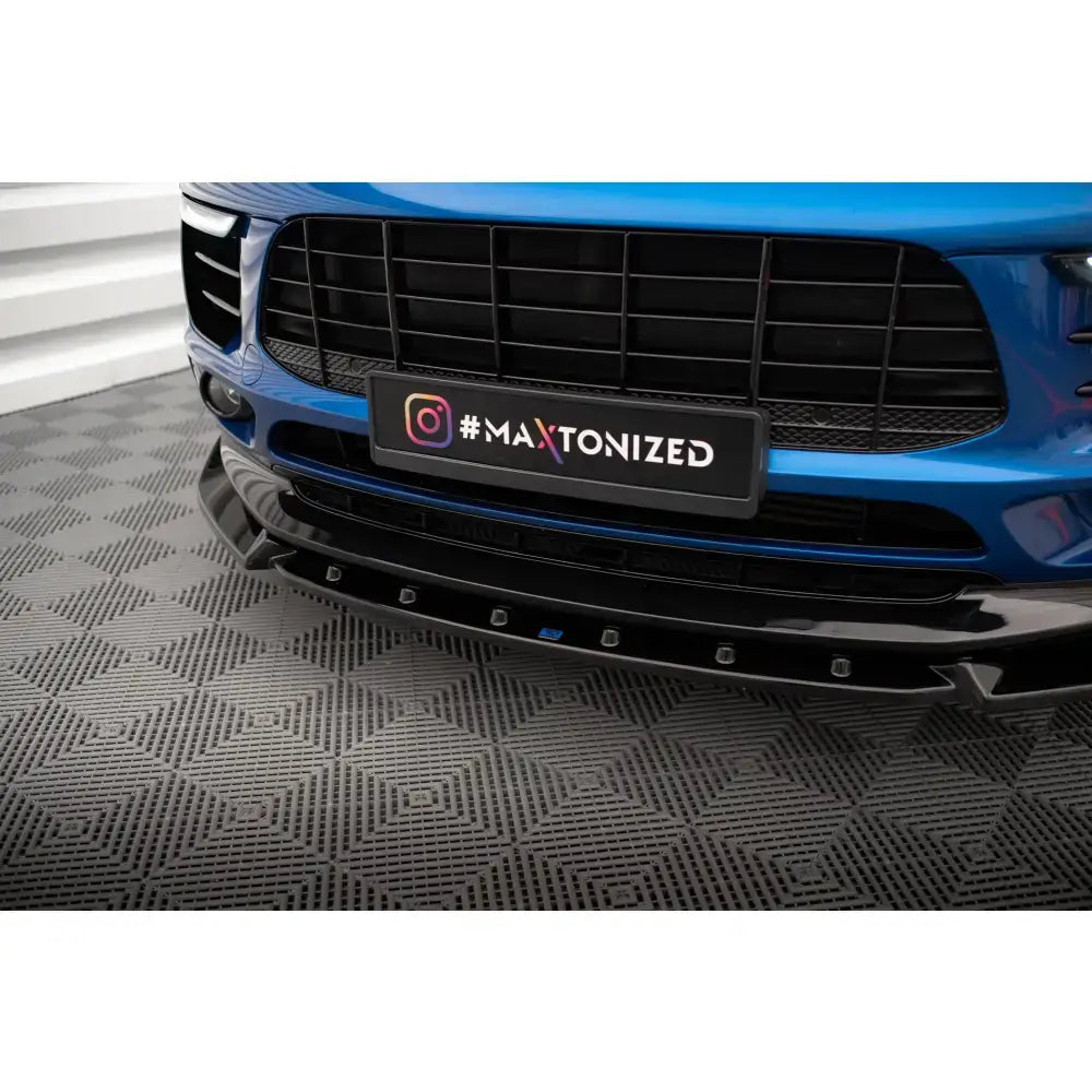 Front lip på Porsche Macan Mk1 viser blank, sort frontsplitter i plast sett fra lav vinkel.
