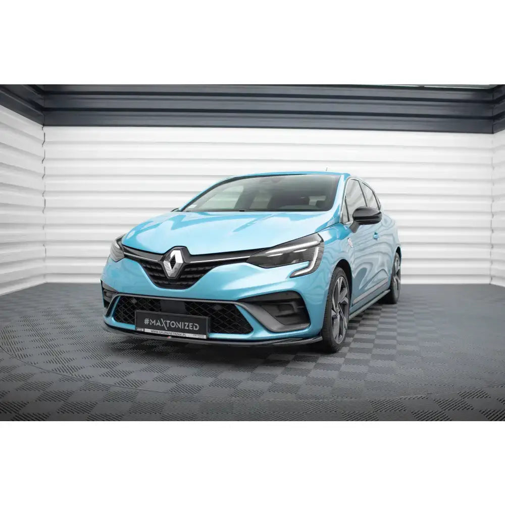 Frontspoiler på Renault Clio RS Line Mk5, lyseblå bil med sorte detaljer og sportsfelger i lyst rom.