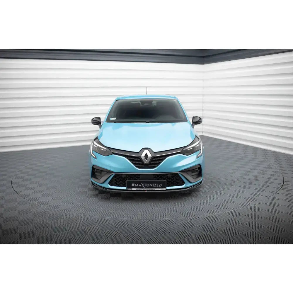 Frontsplitter på Renault Clio RS Line Mk5 i lyseblått, frontvisning på mørkt rutegulv.