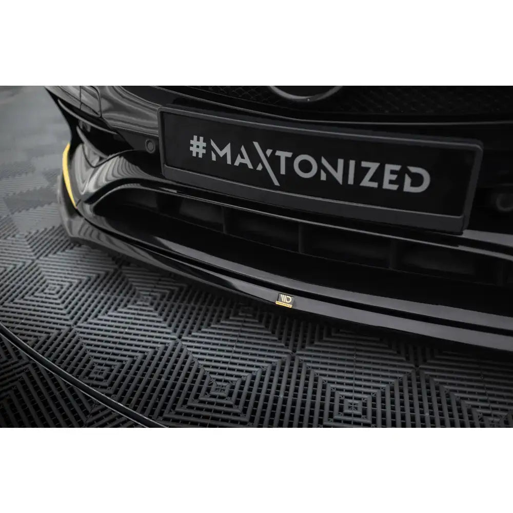 Frontsplitter til Mercedes-AMG CLA 45 V3 i sort blank plast med gul sidekant, sett skrått forfra.