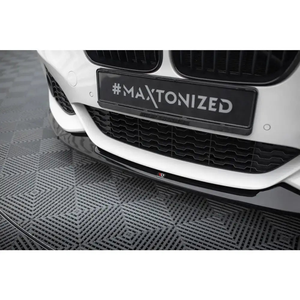 Frontsplitter til BMW 1 M-Pack F20 Facelift, svart spoiler montert under hvit bils frontfanger.