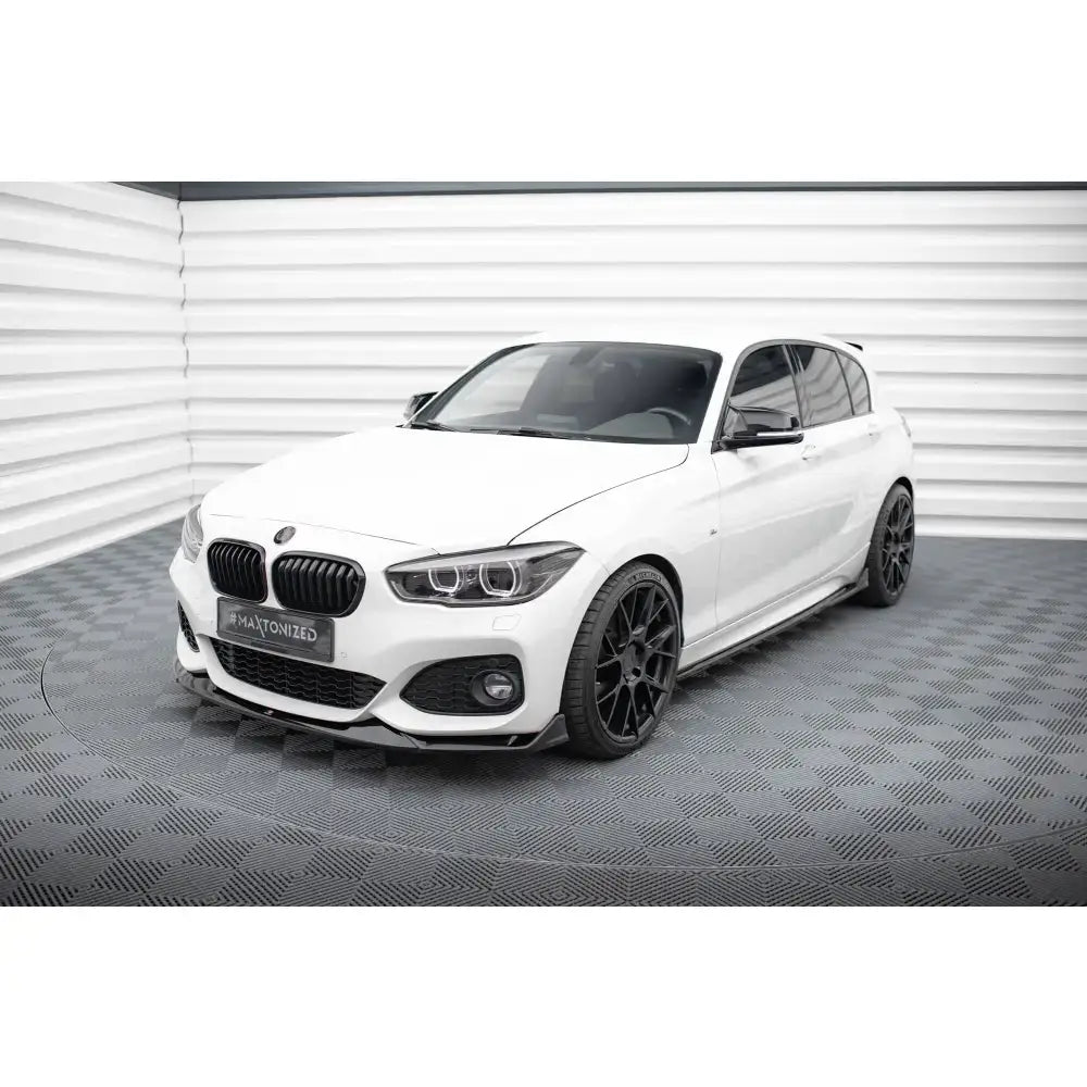 Front lip på hvit BMW 1 M-Pack F20 Facelift med svarte felger og sotede vinduer innendørs.