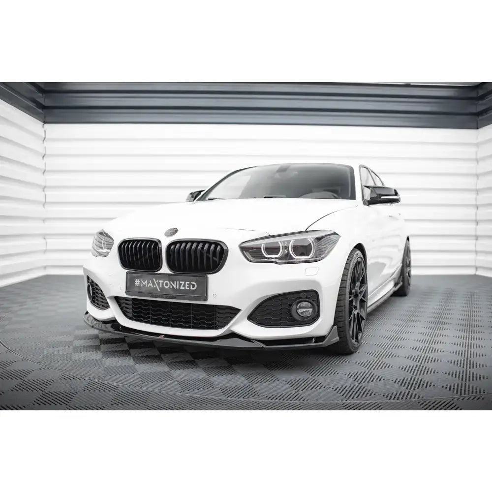 Front splitter på BMW 1 M-Pack F20 Facelift med svarte detaljer sett forfra i lyst rom.