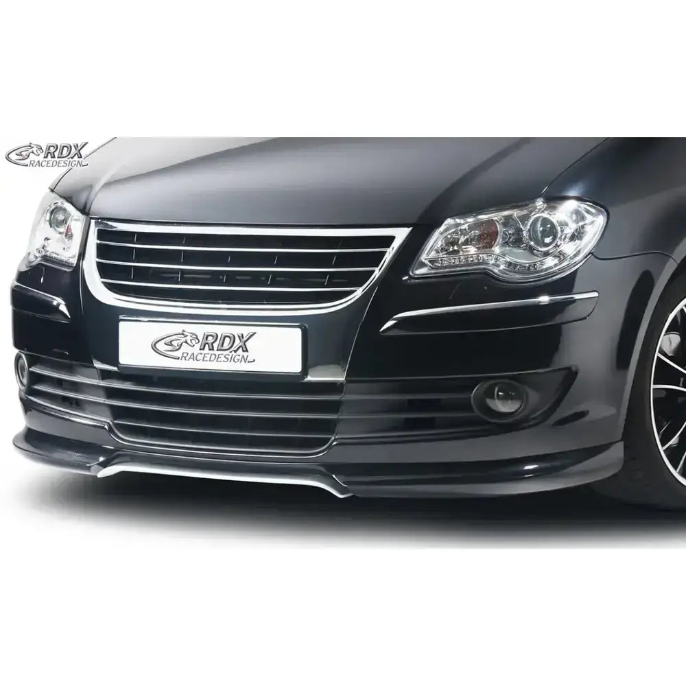 Frontspoiler til Volkswagen Touran 07-10 i sort plast, montert på bilens front med synlig grill og lykter.