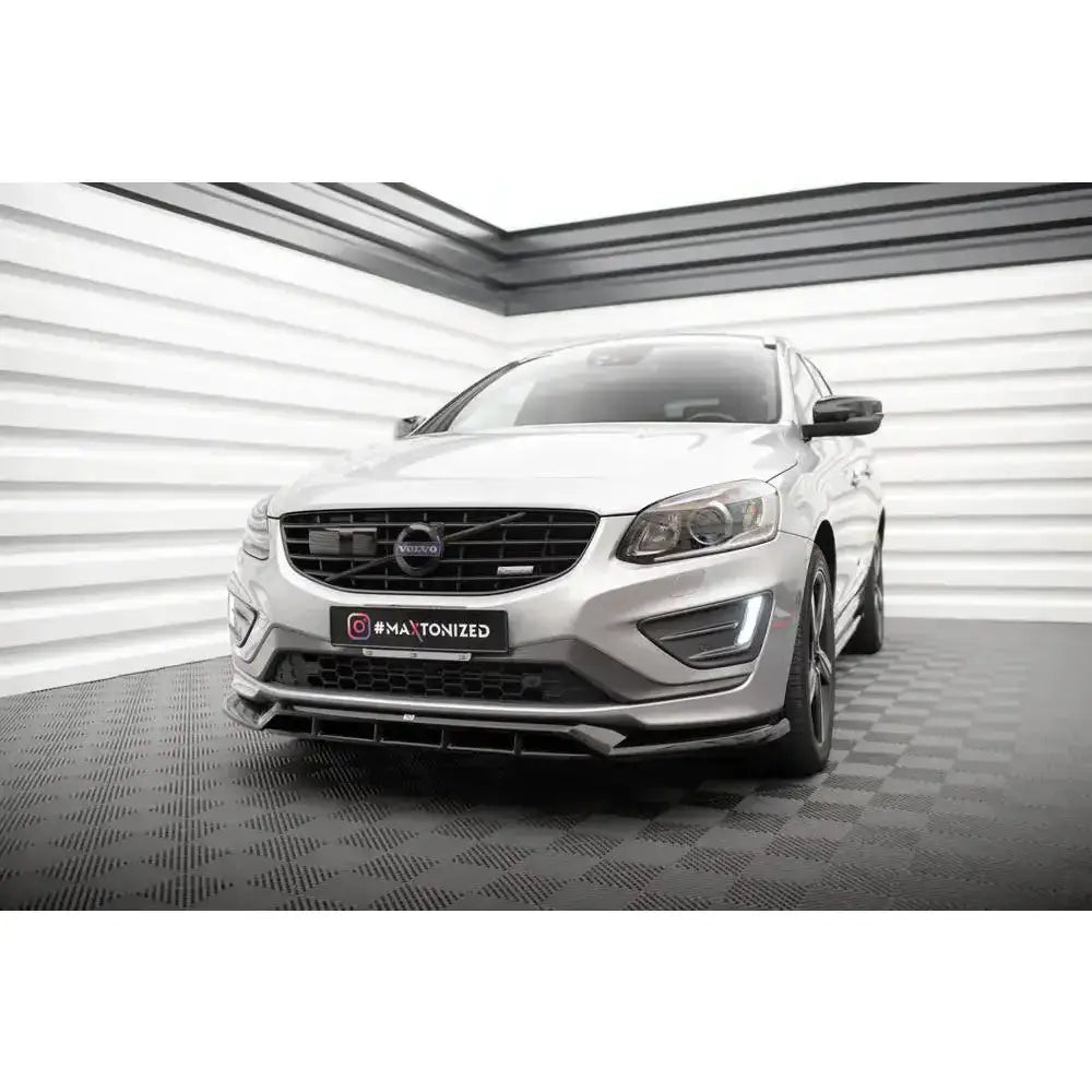Frontsplitter på Volvo XC60 13-17 R-Design med svarte detaljer og sølvfarget karosseri innendørs.