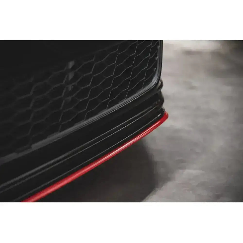 Frontspoiler til VW Golf 7 GTI TCR med svart bikubemønstret grill og rød kant mot asfalt.