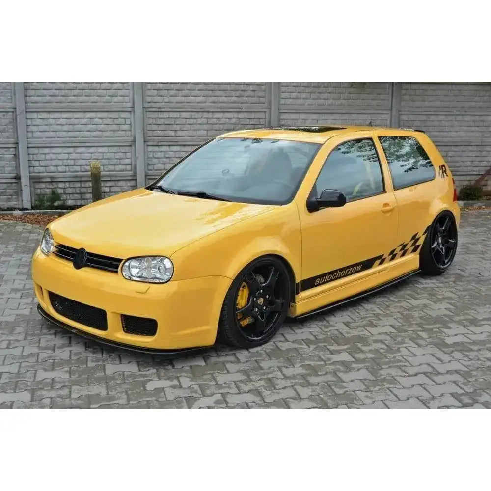 Frontspoiler på gul VW Golf IV R32 med svarte felger og sjakkmønster-dekor på dørsiden.