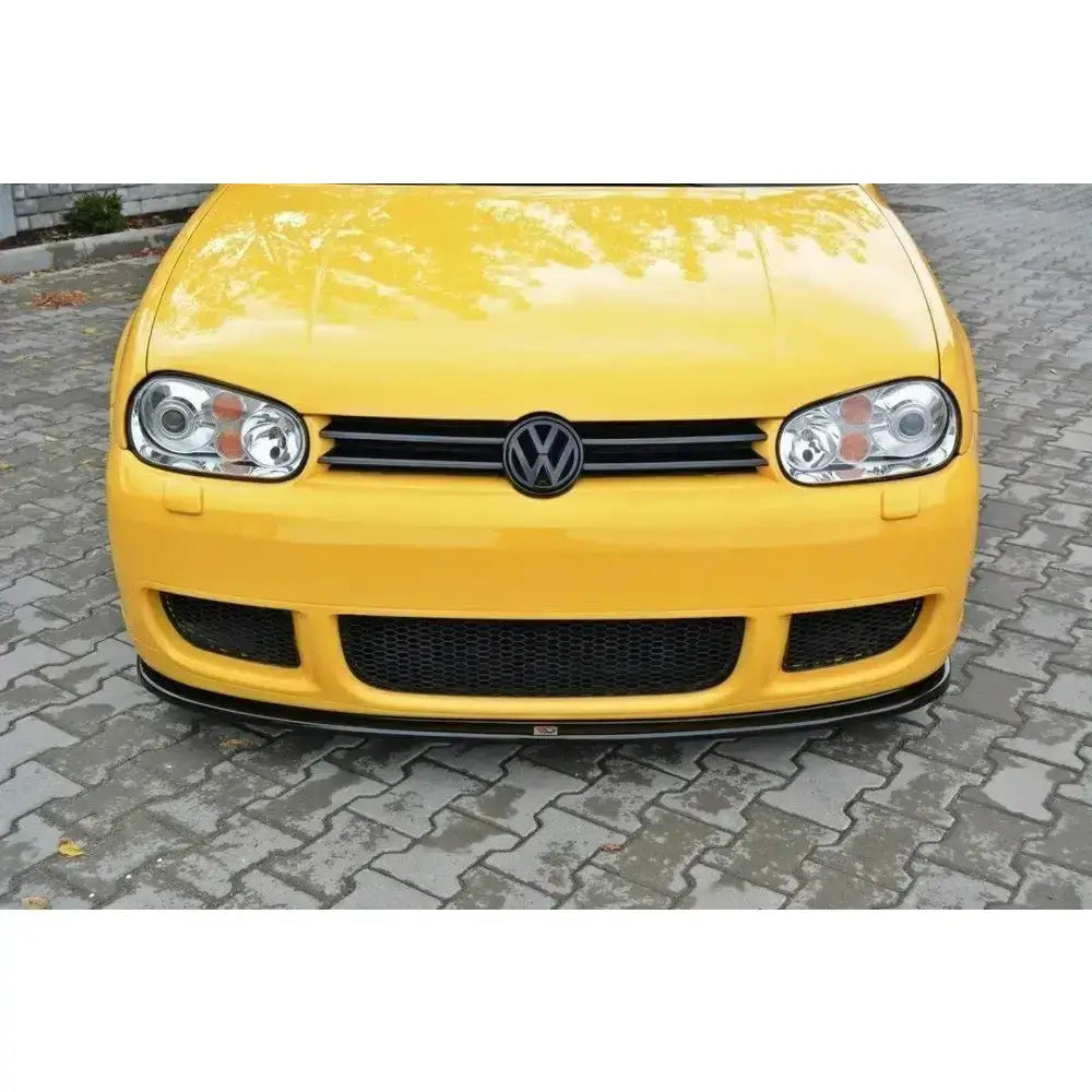 Frontsplitter til Vw Golf IV R32, gul bil med svarte detaljer sett rett forfra på brostein.
