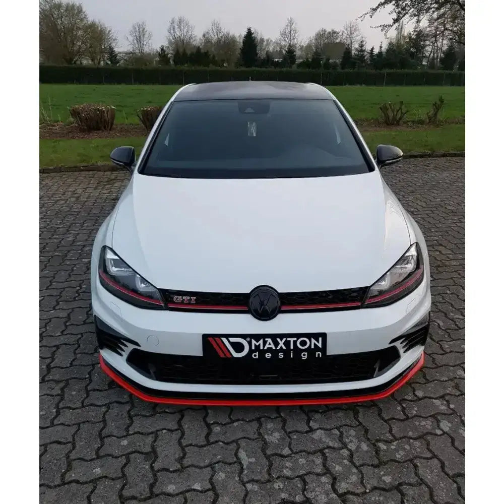 Frontspoiler på Vw Golf Mk7 Gti Clubsport med rød stripe og svarte detaljer, parkert på belegningsstein.