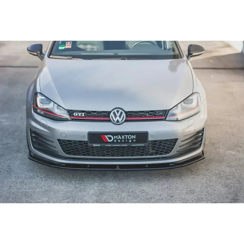 Frontspoiler på VW Golf VII GTI med sort Maxton Design-leppe og rød stripe i grillen.
