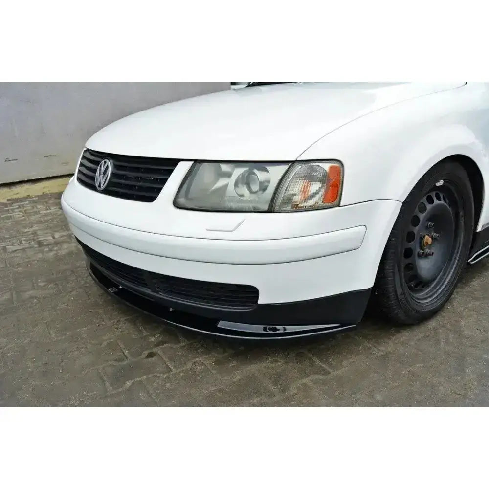Frontspoiler til VW Passat B5 montert under støtfanger på hvit bil, sett fra venstre hjørne.