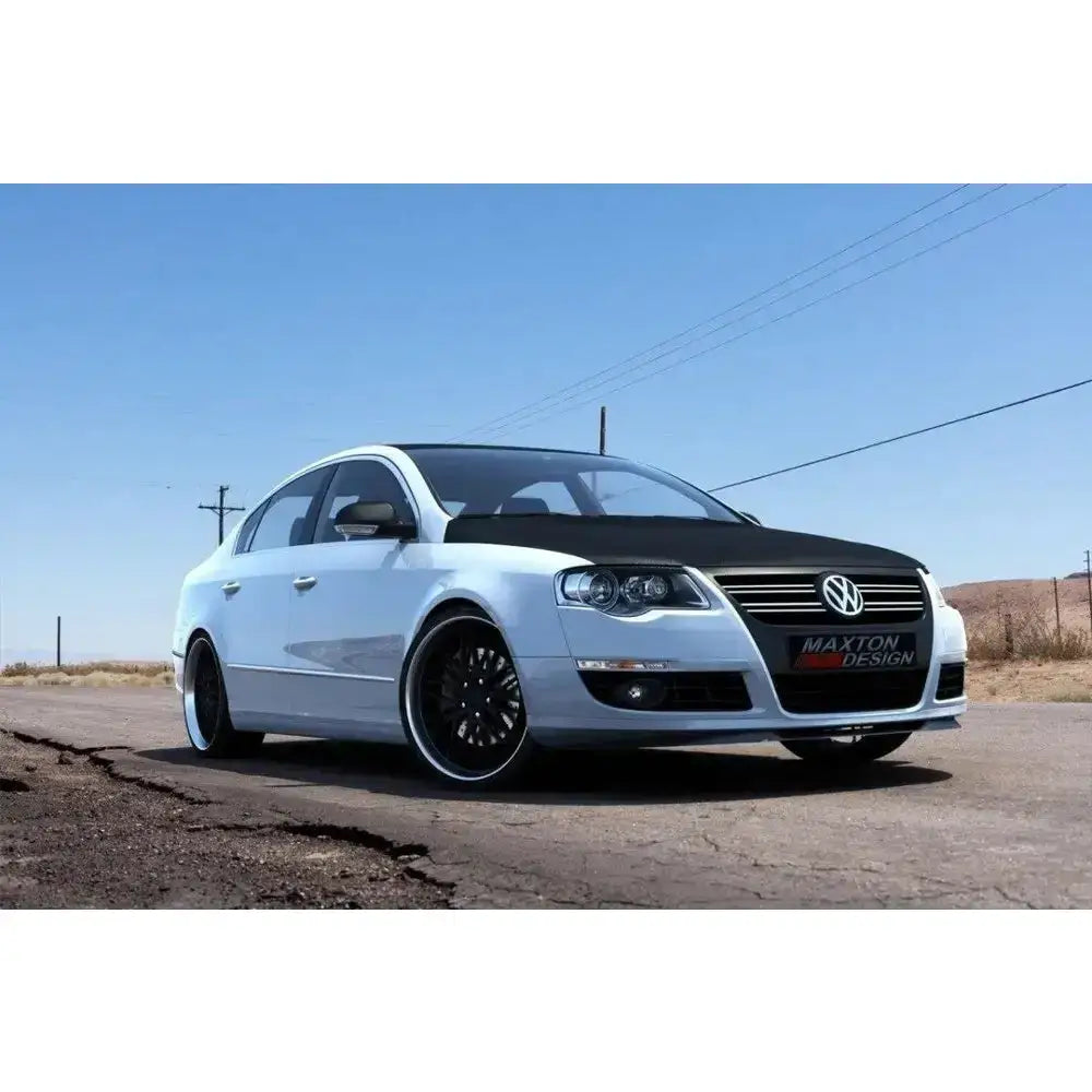 Frontleppe VW Passat B6 montert på hvit sedan med svart panser og svarte felger på landevei.