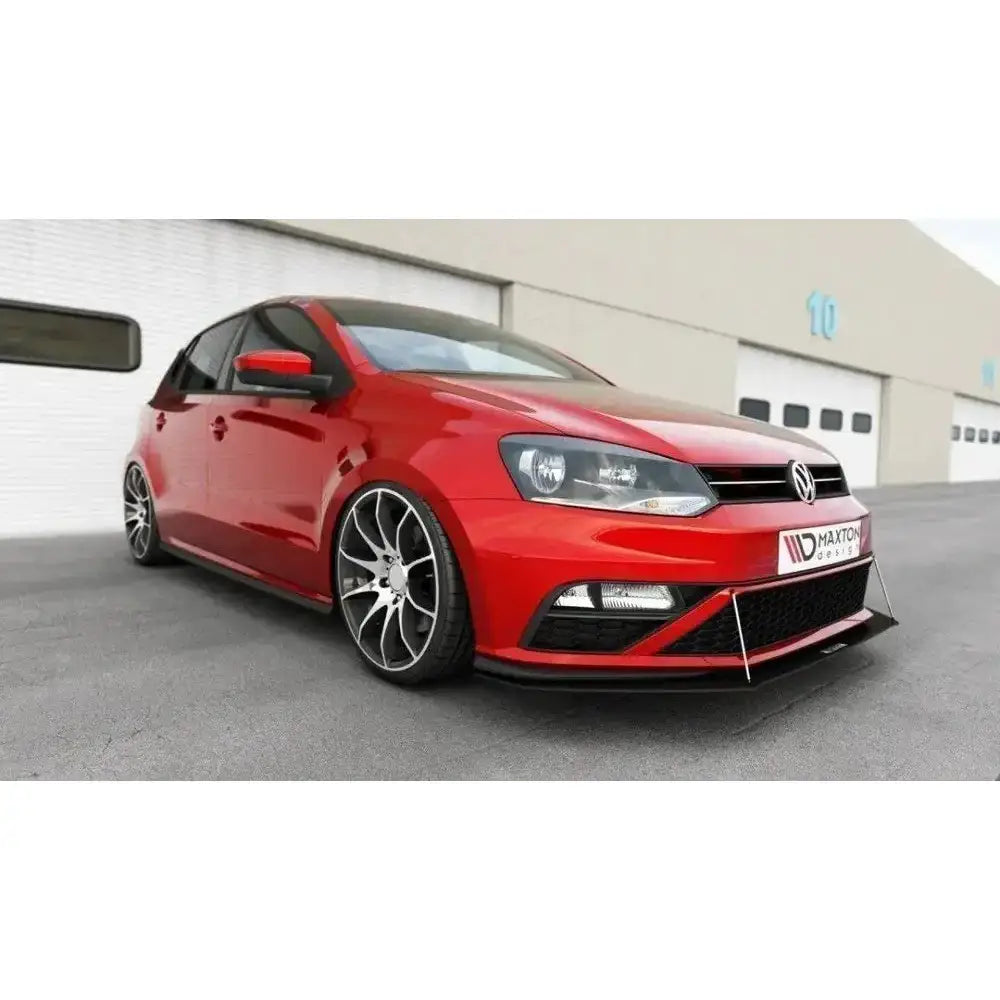 Frontspoiler på rød VW Polo Mk5 GTI Facelift med sorte felger og senket understell foran lagerbygning.