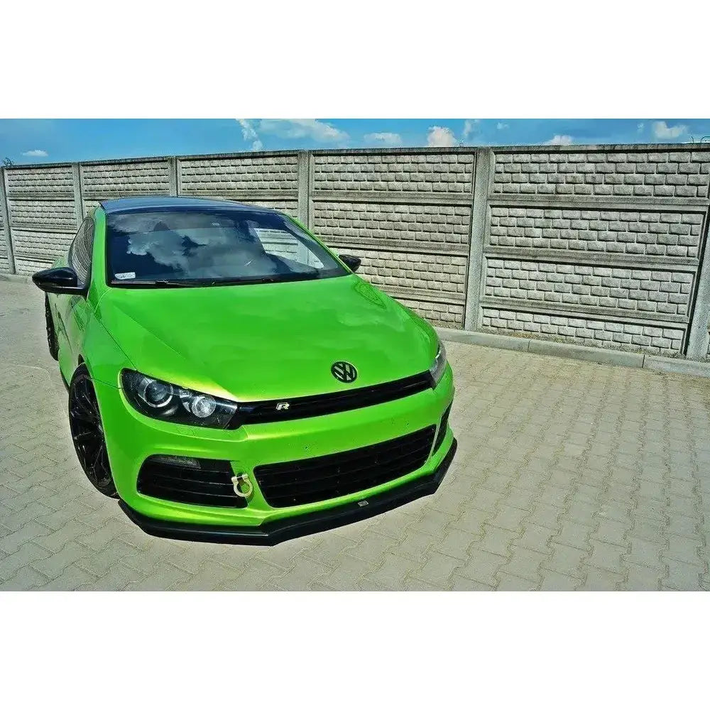 Frontsplitter på grønn VW Scirocco R Ver2 med svart panserdetalj og spoiler, parkert foran murvegg.