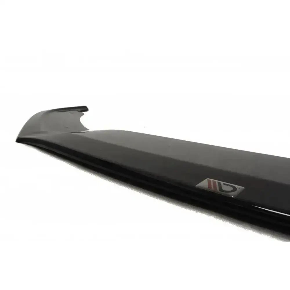 Front splitter Vw Scirocco R Ver2 i sort karbonfiber med glatt overflate og logo, sett fra skrå vinkel.