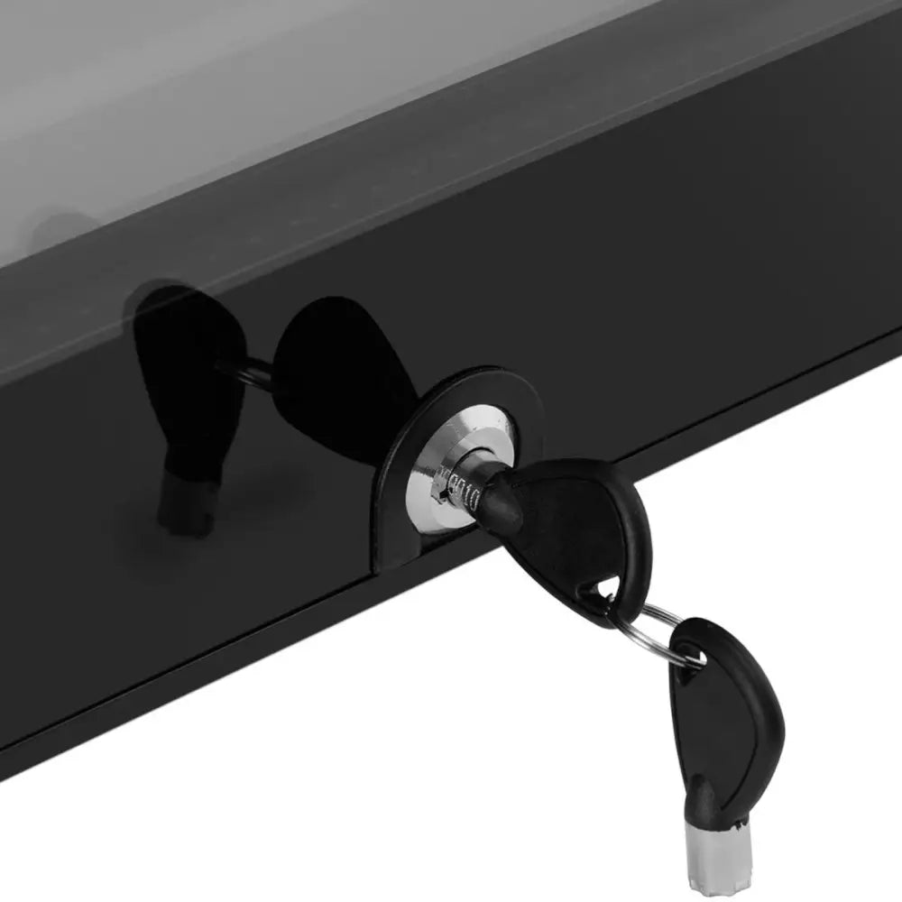Kjøleskap hotellskap, detalj av sort dør med metallisk lås og to svarte nøkler hengende i låsen.