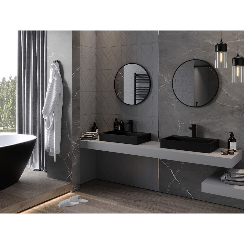 Speil baderom Mexen Loft rundt speil med svart ramme over svarte vasker og grå marmorerte vegger.