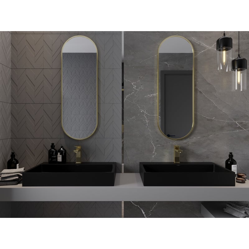 Speil til baderom ovalt Mexen Loft med gull ramme over sorte servantsett og grå marmorfliser.